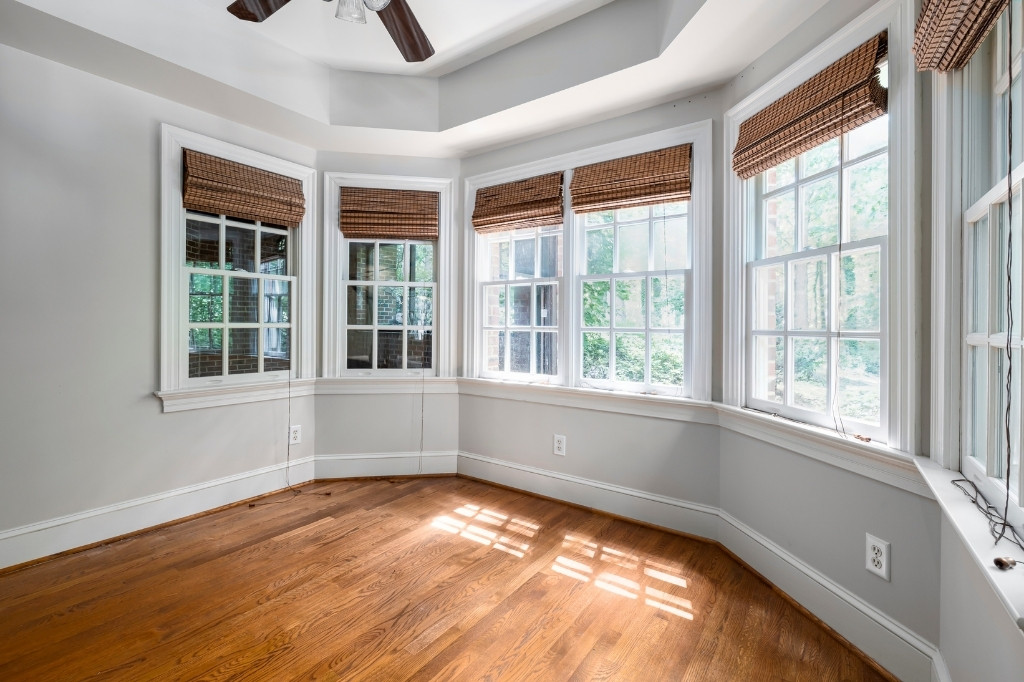 Homeowner cleaning residential windows to keep them streak free between professional services in Connecticut